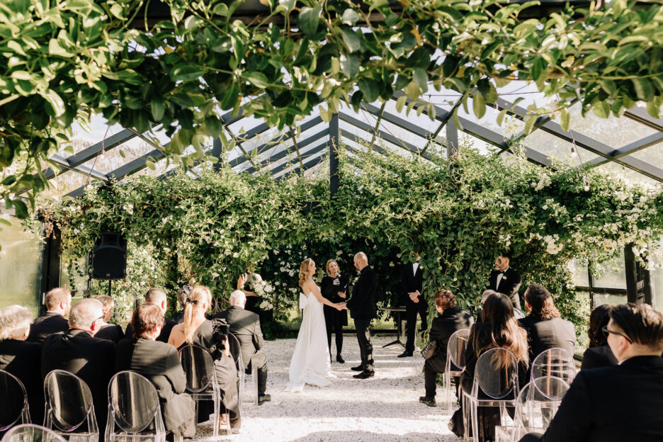 wedding ceremony in progress in glass house black walnut Tauranga venue