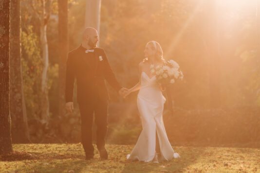 bride and groom in golden light as sun rays come down