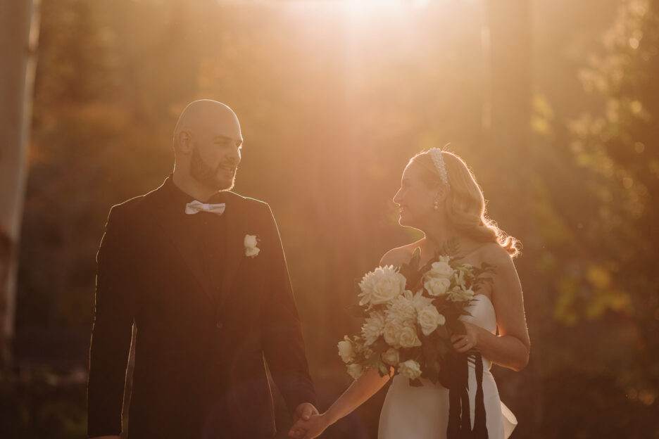 wedding couple walking in golden light looking at each other very happy