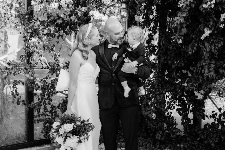 bride and groom during family photo with their young son