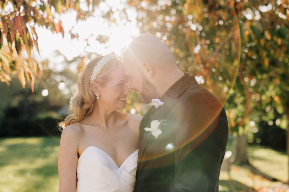 bride and groom cuddling with sun rays