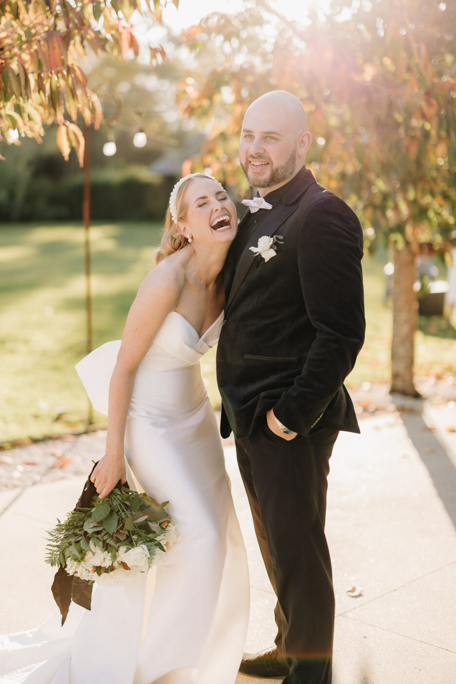 bride and groom enjoyment with sun behind them and autumn leaves