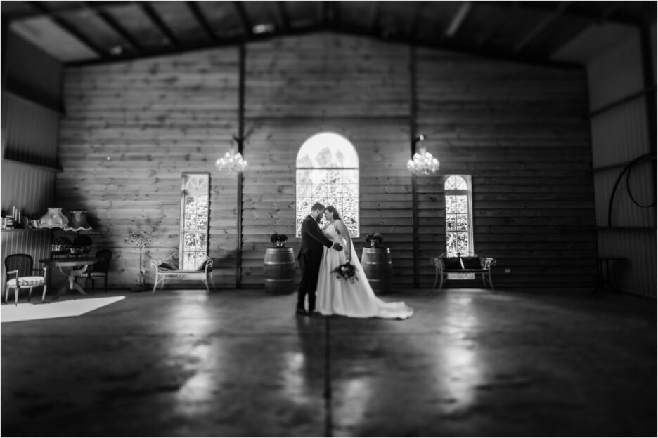 bride and groom photo heads together inside ebony vines in a rustic industrial setting in packing shed