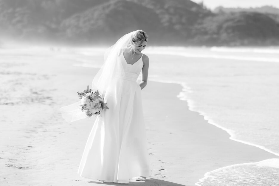 bride avoiding the waves on waihi beach