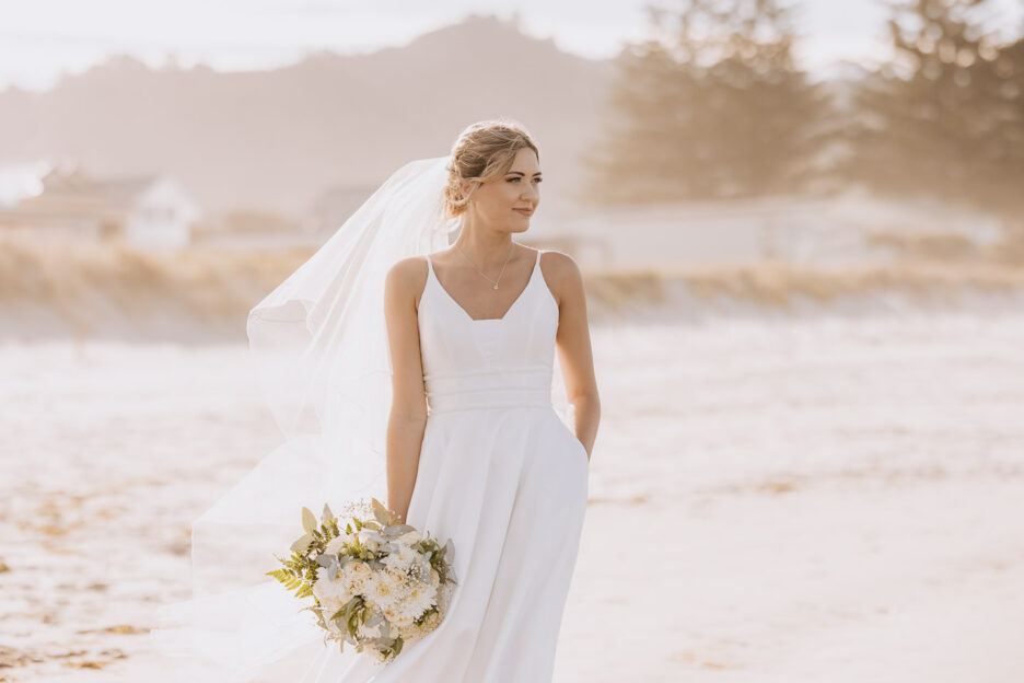 golden hour photo of bride looking to sea hand in pocket of dress