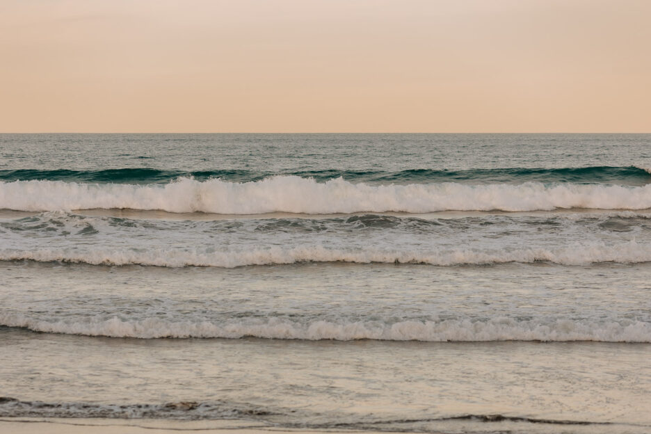 Sunset behind waves waihi beach