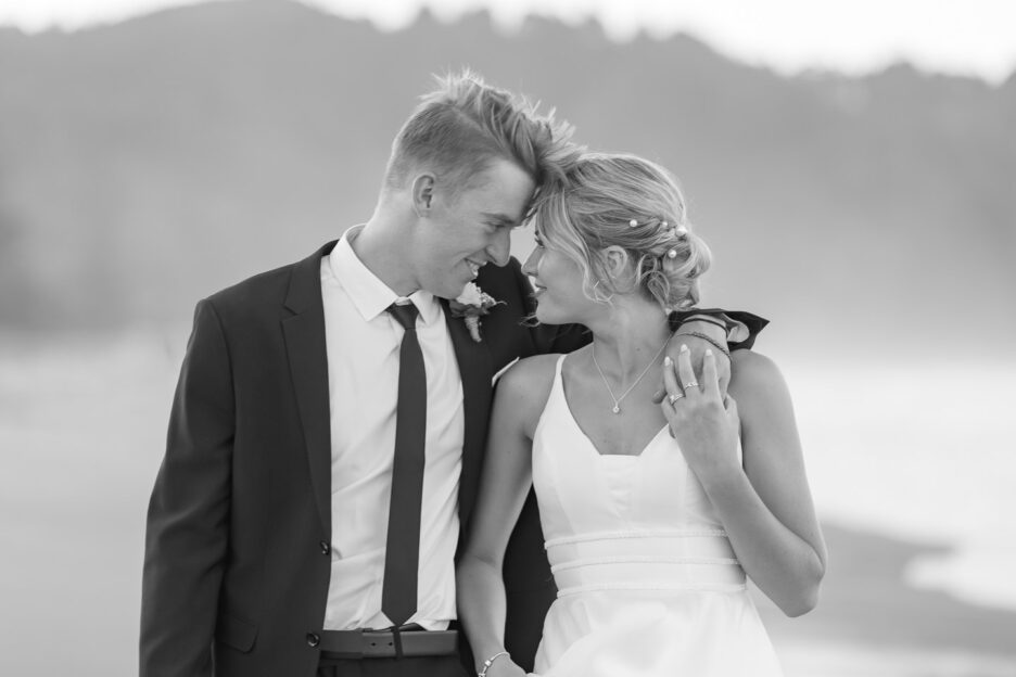 intimate photo of wedding couple foreheads together walking waihi beach