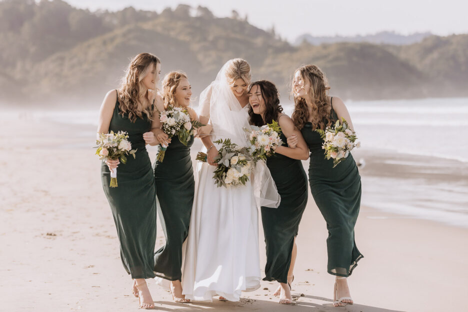 bridesmaids laughing while walking waihi beach