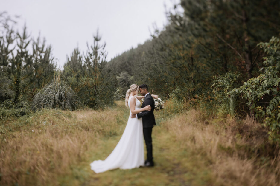 classic photo of bride and groom taken with tilt shift lens on forest lane behind old forest school venue