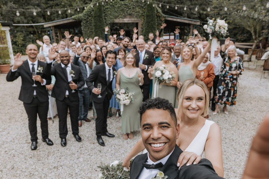 selfie with bride and groom with wedding guests at old forest school