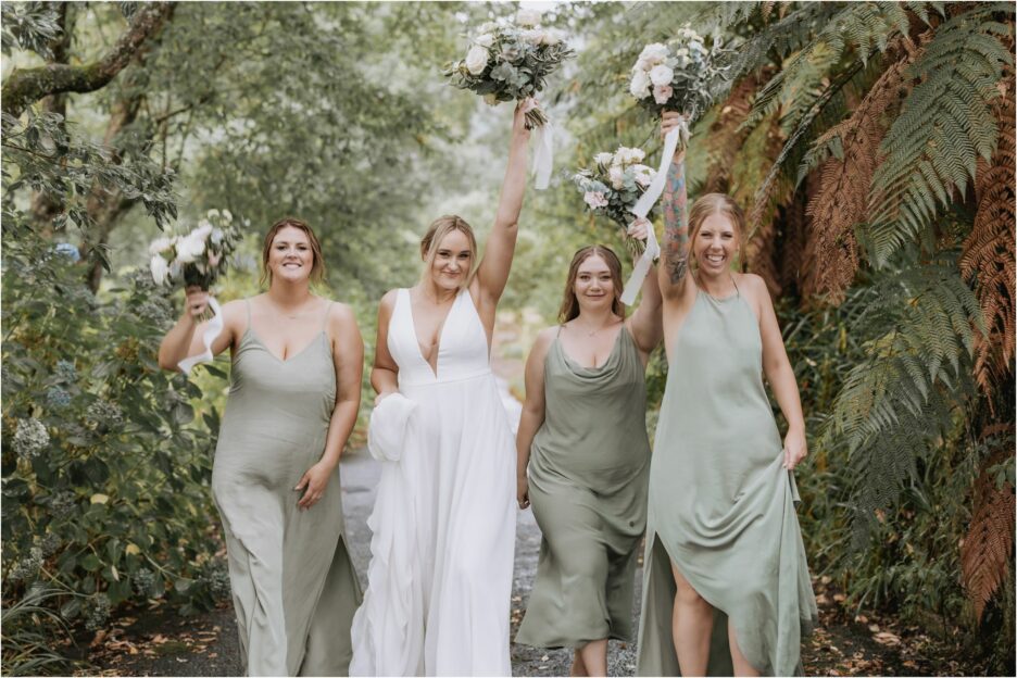 bride and her bridesmaids celebrating with flowers in air