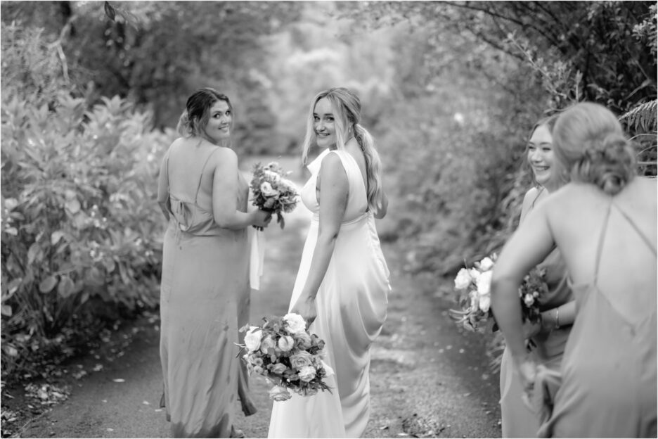 bride walks away with bridesmaids with cheeky look over her shoulder