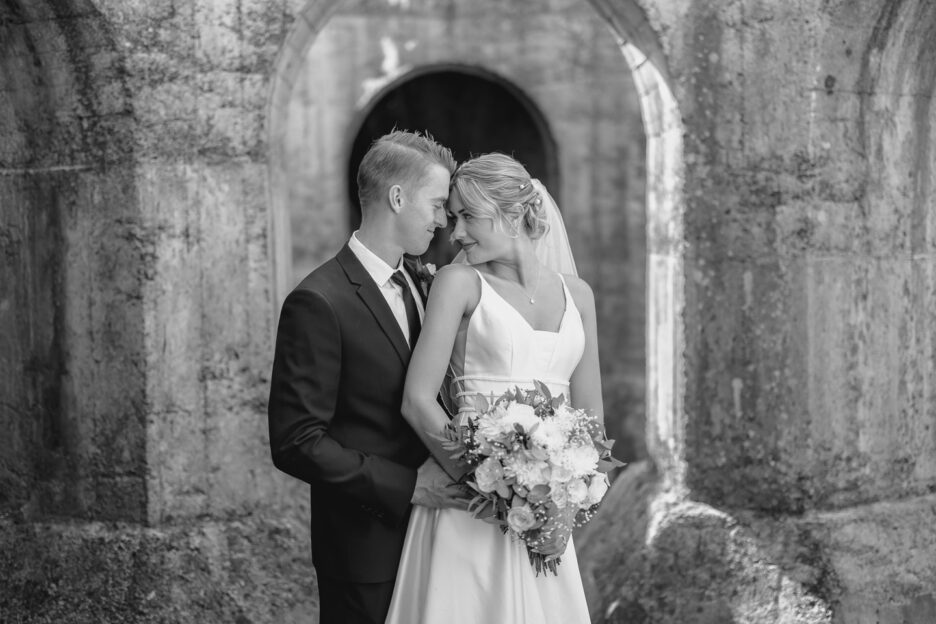 bride cuddles in groom in old new zealand ruins outside of waihi