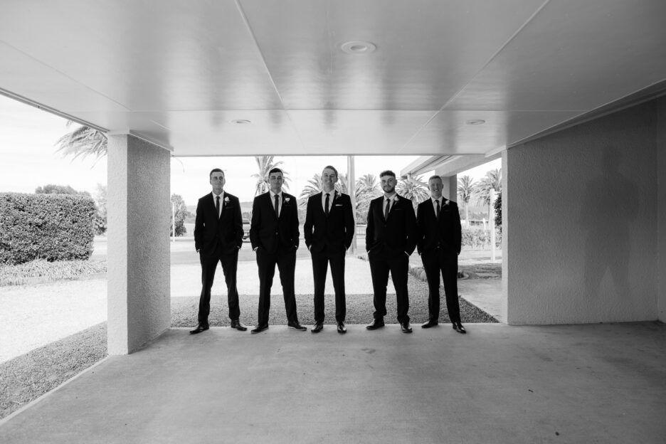 Groomsmen looking like men in black with shadow on wall