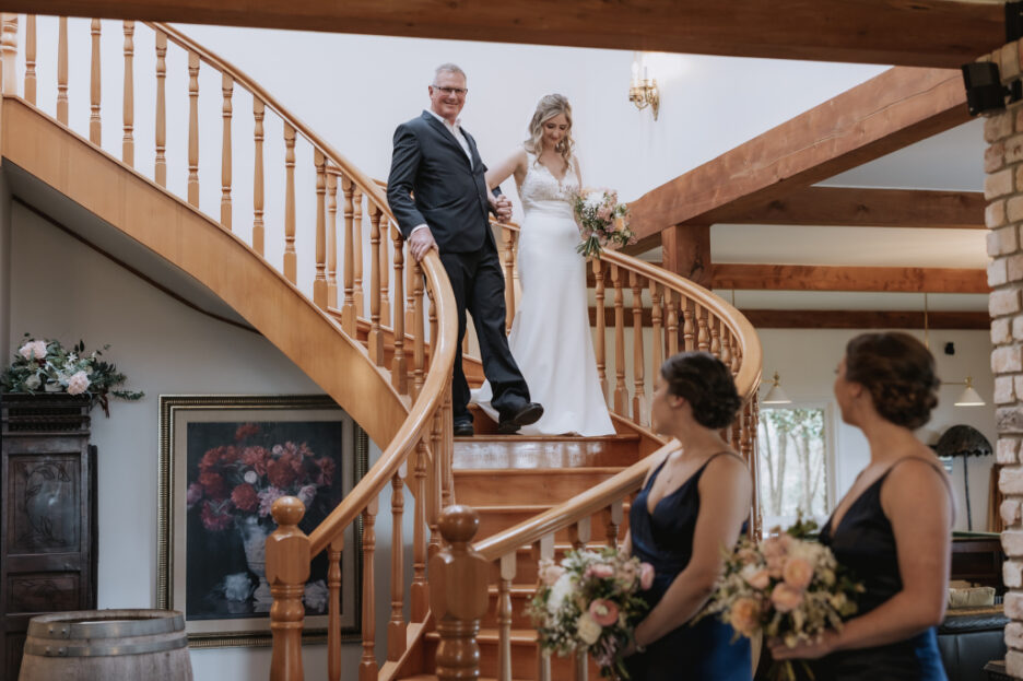 bride walks down staircase at eagle ridge