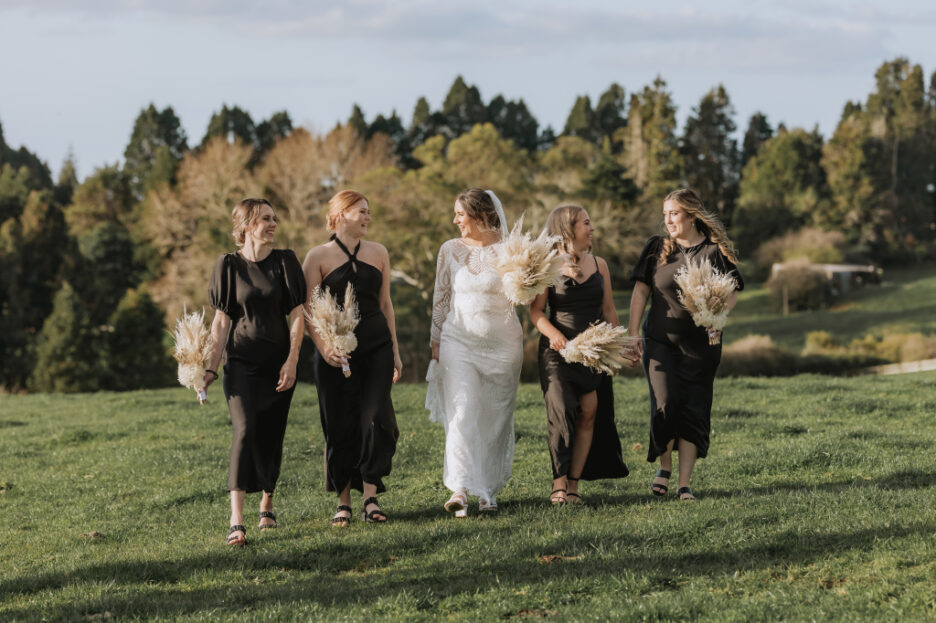 Happy bride with bridesmaids walking across paddock eagle ridge estate