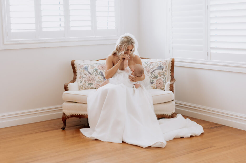 bride feeds her baby on couch inside lodge accommodation at eagle ridge