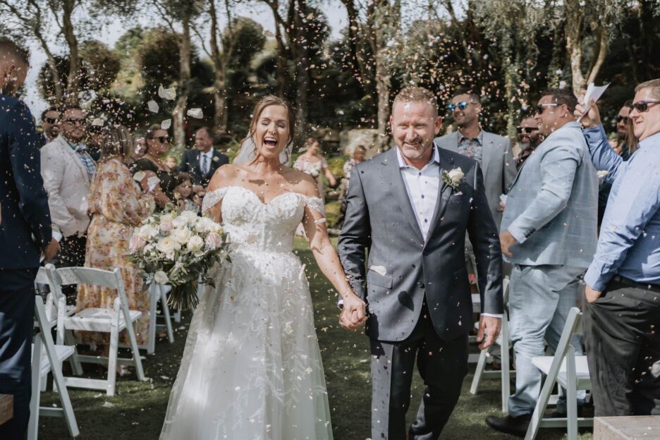 bride and groom exit aisle with confetti