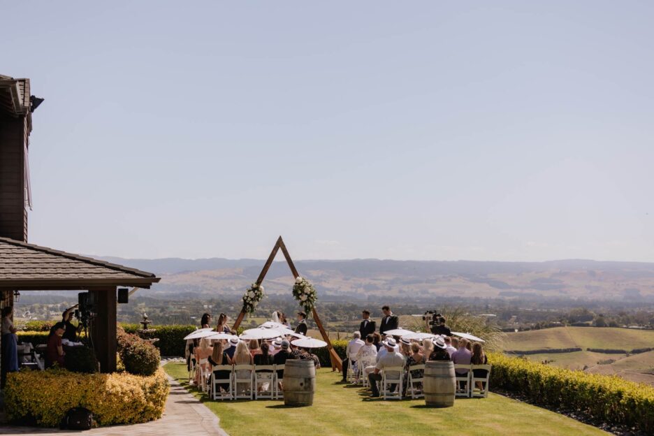 Wedding ceremony on lawn with Kaimais background
