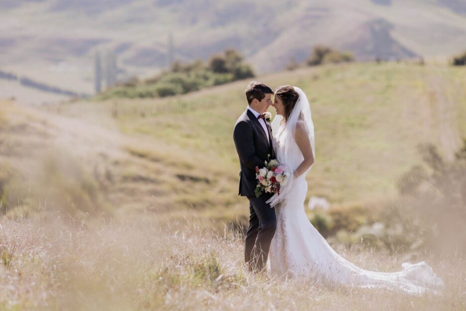 bride and groom in summer time in high grass on hill