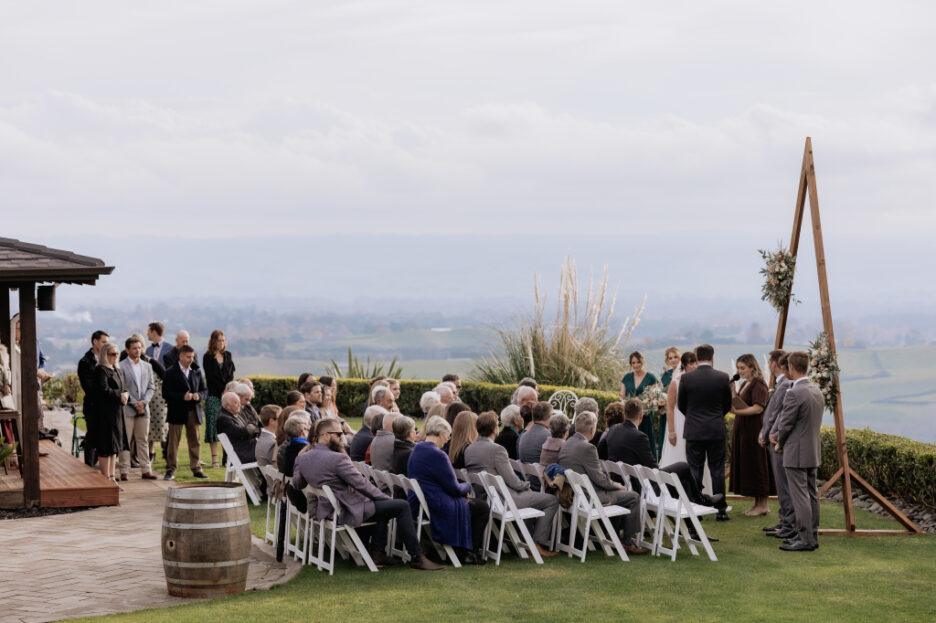 ceremony in progress on lawn bridesmaids in green